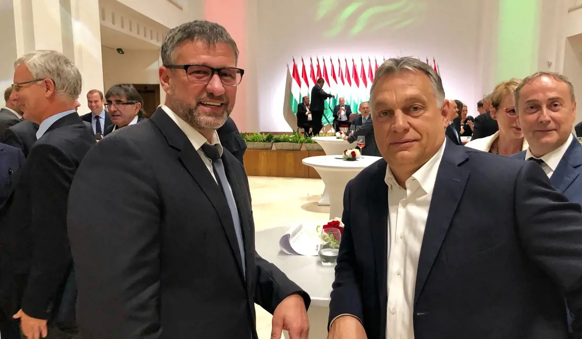 Költségvetési csalással gyanúsítják, Orbánnal fotózkodik